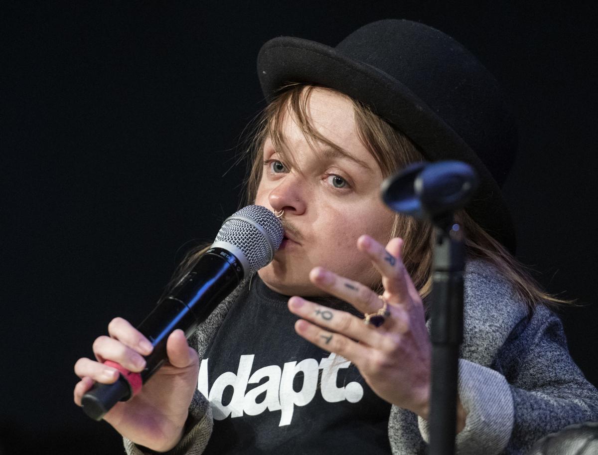 Woman in black bowling hat speaks into a microphone