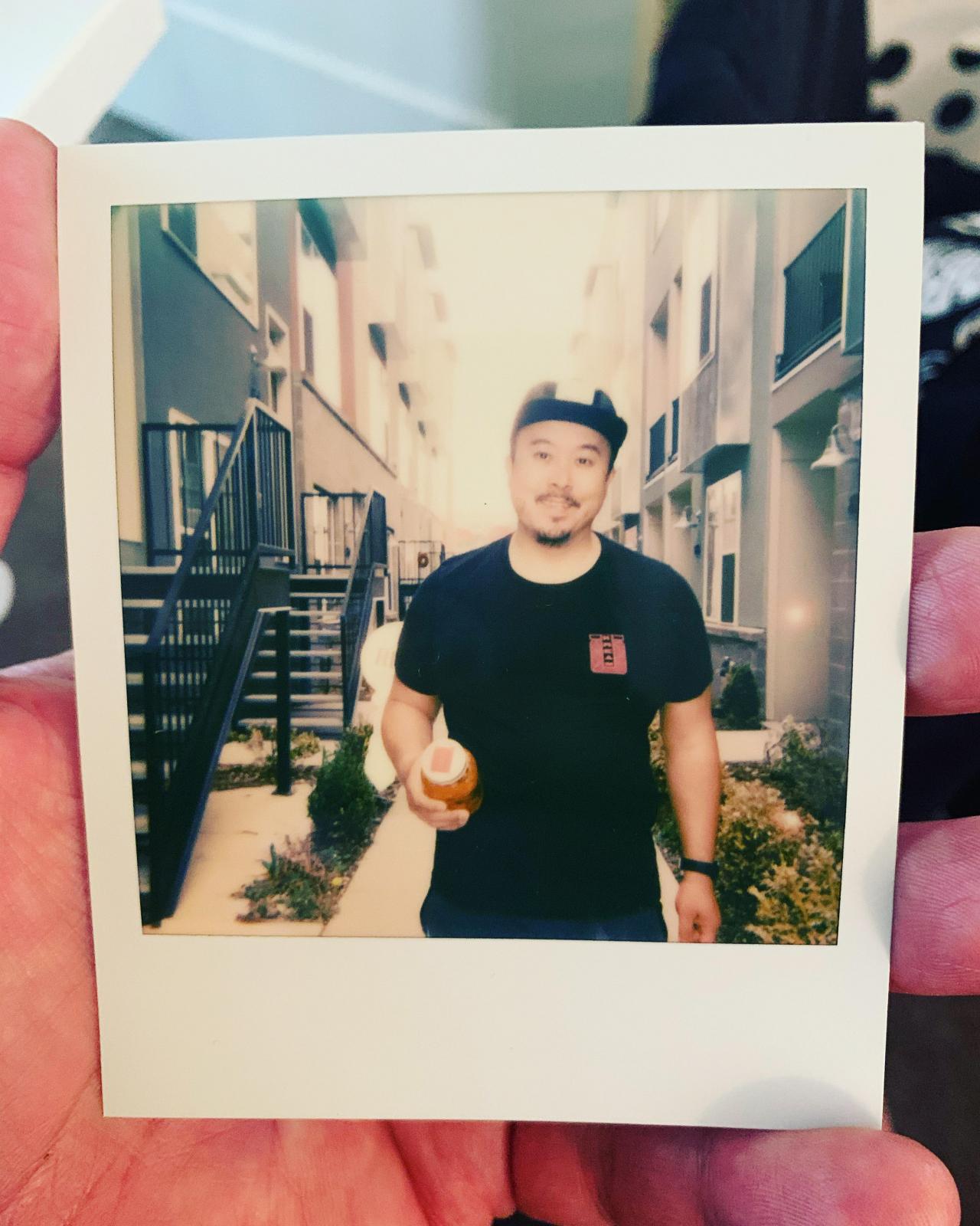 Polaroid of man in hat and black t-shirt