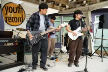 A group of young artists perform together on stage